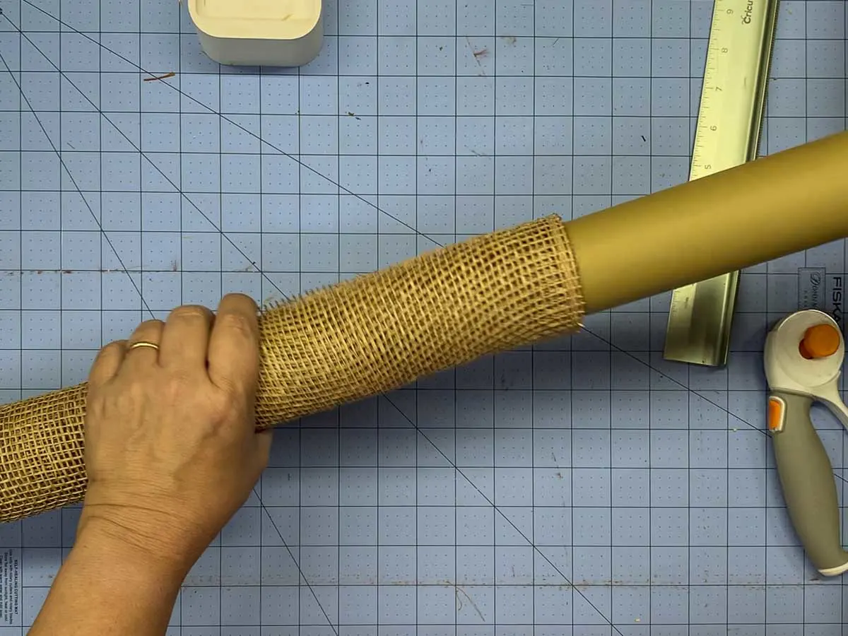 Removing a cardboard tube from a roll of poly burlap mesh.